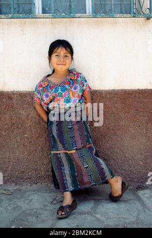 Porträt eines Maya-Mädchens in traditioneller Kleidung: Handgewebtes Huipil (Bluse), faja (Gürtel) und corte (Rock) aus jaspe-Stoff. Almolonga, Guatemala Stockfoto