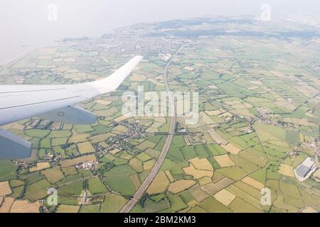 Herrlicher Blick von oben auf die grüne Landschaft. Blick von oben vom Flugzeugfenster über einen Flügel, der hoch über Ackerland und Feldern fliegt. Landwirtschaft und Stockfoto