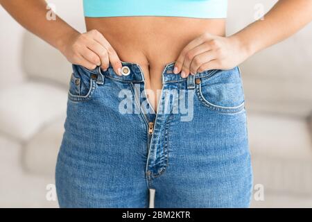 Frau Versucht, Zip-Up Jeans Nach Gewichtszunaufnahme, Cropped Stockfoto