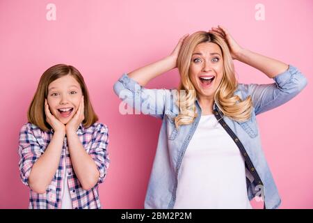 Erstaunt positive blonde Haare Frau Kind Mutter Tochter hören unglaubliche Familie Schnäppchen Rabatt berühren Kopf Hände schreien tragen karierte Denim Jeans Stockfoto