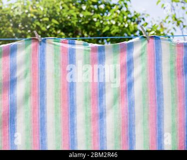 Frisch gewaschene Handtücher oder Laken hängen zum Trocknen an einer Wäscheleine. Stockfoto