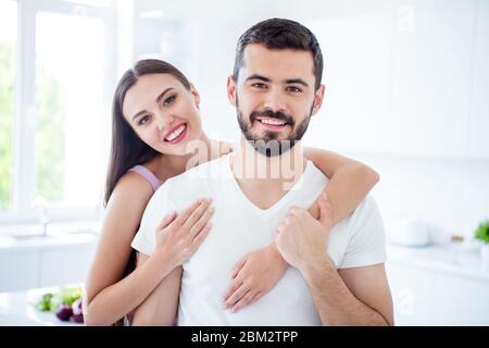 Porträt der positiven Ehepartner Frau Umarmung Huckepack Mann genießen zu Hause Quarantäne Ruhe Entspannen Sie sich zusammen im Haus Küche Wohnung drinnen Stockfoto