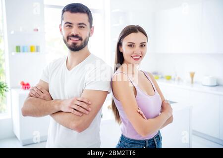 Porträt von fröhlich cool smart unabhängig verheirateten Paar Kreuzhändige stehen zurück zu zurück genießen zu Hause bleiben Quarantäne Ruhe entspannen in Küche Haus Stockfoto