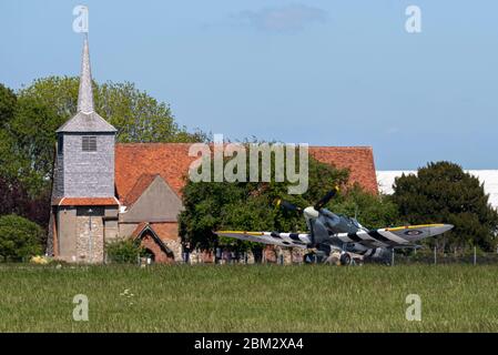 Royal Air Force Battle of Britain Memorial Flight Spitfires besuchte den Flughafen Southend zwei Tage vor dem VE Day auf einem Drehflug. Sie fahren an der Kirche vorbei Stockfoto