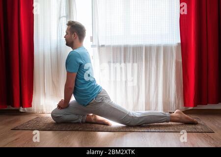 Mann, der eine einbeinige Königstaube oder eka pada macht Rajakapotasana Stockfoto