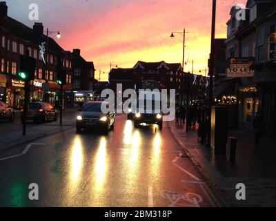 Heath Road in Twickenham bei Sonnenuntergang an einem Herbst-/Winterabend, wenn die Straße nass ist und die Scheinwerfer die rutschige, glänzende Oberfläche beleuchten. London. GROSSBRITANNIEN. (Vorratshaltung) Stockfoto