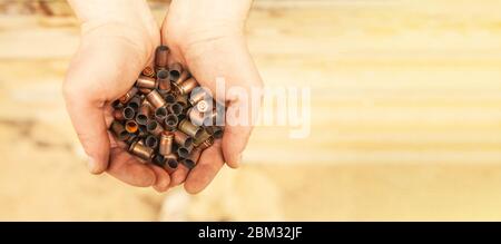 Geschoss-Gehäuse nach einem Schuss aus Militärpatronen in die Hände eines Soldaten. Stockfoto