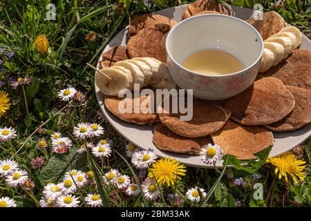 Zum Frühstück gibt es eine Nahaufnahme von leckeren Pfannkuchen mit Honig und Banane Stockfoto