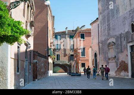 Тourists eine schöne Straße entlang zu einer Brücke in Venedig zu gehen. Blick auf die Brücke Ponte Storto in der Nähe der Kirche San Marcuola, Cannaregio Bezirk Stockfoto