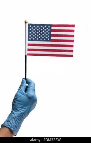 Handtragen Schutzhandschuh hält amerikanische Flagge isoliert auf weiß. Konzept des Pandemieausbruchs in den USA müssen die Menschen Gummihandschuhe tragen Stockfoto