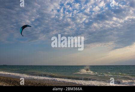 Kitesurfer reitet ein Kite-surfen auf den Wellen des Meeres in einen kleinen Sturm im Sommer Stockfoto