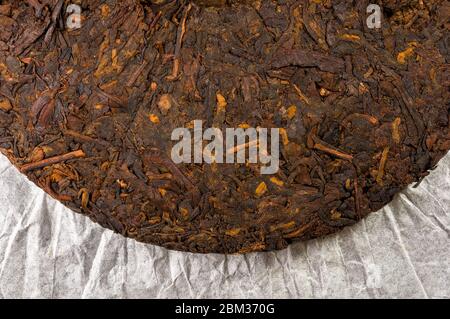 Chinesisch gepresster PU-erh Tee auf Geschenkpapier, Nahaufnahme Stockfoto