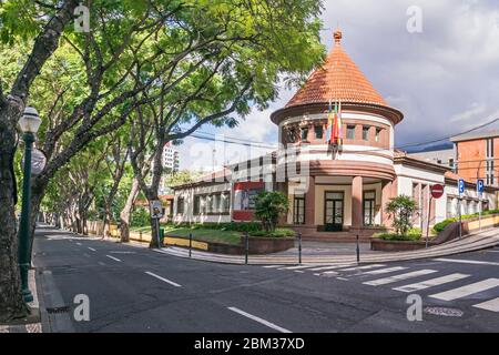 Funchal, Portugal - 10. November 2019: Gesäumt von subtropischen Bäumen Straße Rua Joao de Deus mit dem Gebäude der Henrique und Francisco Franco M Stockfoto