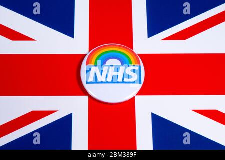 London, Großbritannien - 5. Mai 2020: Ein Pin-Abzeichen mit dem Symbol des National Health Service und Regenbogen, abgebildet über der britischen Flagge. Stockfoto