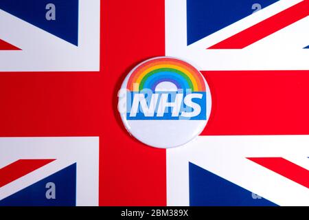 London, Großbritannien - 5. Mai 2020: Ein Pin-Abzeichen mit dem Symbol des National Health Service und Regenbogen, abgebildet über der britischen Flagge. Stockfoto