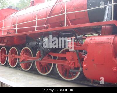 Alte russische Lokomotive. Dampflokomotive mit roten Rädern. Retro Lokomotive auf Schienen. Alte seltene sowjetische Eisenbahn Transport. Rote Räder einer alten Lokomotive Stockfoto