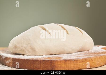 Frischer Teig, der zum Backen von Brot auf dem Schneidebrett bereit ist. Nahaufnahme Stockfoto