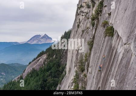 Zwei Männer hängen am Portaledge auf dem Squamish Chief mit Garibaldi Stockfoto