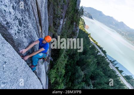 Mann führen Klettern Granit Squamish mit Blick auf den Ozean Stockfoto