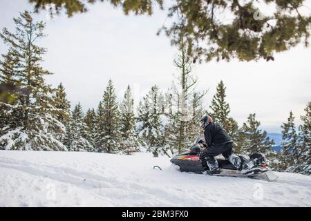 Rentner genießt Schneemobilfahren während der Freizeit Stockfoto