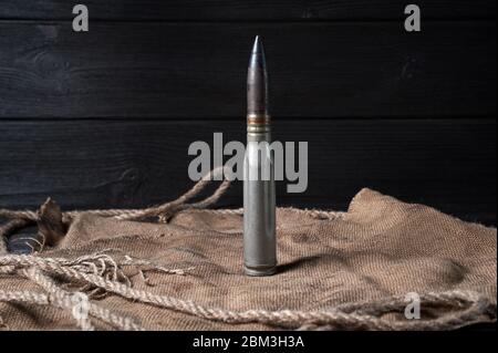 Schwere Patrone auf schwarzem Holzgrund mit Garn und Bläschen, Stillleben Stockfoto