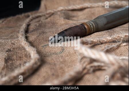 Schwere Patrone auf schwarzem Holzgrund mit Garn und Bläschen, Stillleben Stockfoto