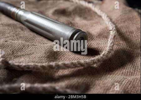 Schwere Patrone auf schwarzem Holzgrund mit Garn und Bläschen, Stillleben Stockfoto