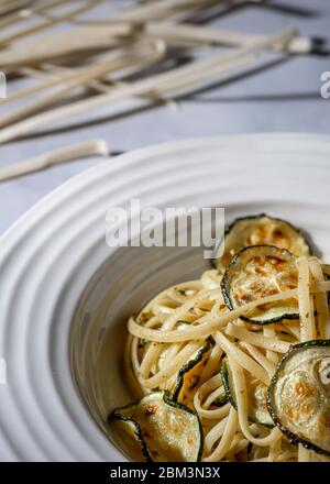 Veganes Gericht. Fettuccine Pasta mit im Ofen gerösteten Zucchini. Stockfoto