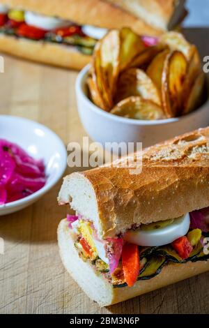 Vegetarisches Sandwich mit gegrillten Zucchini, in Scheiben geschnittenen gekochten Eiern, gerösteten roten Paprika und eingelegten roten Zwiebeln. Stockfoto