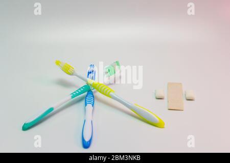 Zahnbürsten und Kaugummi auf weißem Hintergrund.Mundfrische Stockfoto