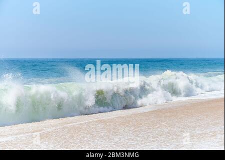 atlantische grüne Wellen schlagen am Strand am Nordstrand von Nazaré Stockfoto