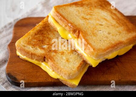 Hausgemachtes Gegrilltes Käse-Sandwich auf einem rustikalen Holzbrett, Seitenansicht. Nahaufnahme. Stockfoto