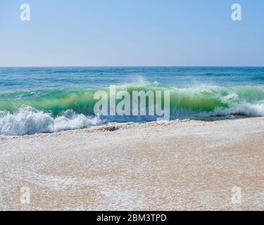 atlantische grüne Wellen schlagen am Strand am Nordstrand von Nazaré Stockfoto