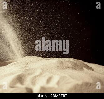 Bewegung von Staubpartikeln auf schwarzem Hintergrund einfrieren. Pulverexplosion. Abstrakte Staubüberlagerung. Stockfoto