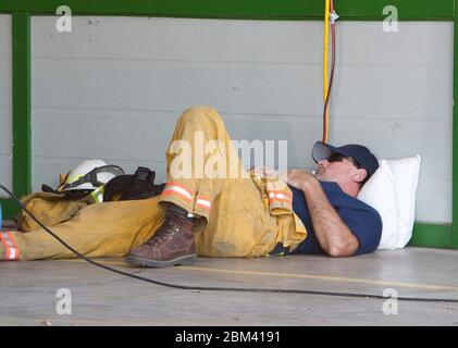 Bastrop Texas, USA, 7. September 2011: Der Feuerwehrmann macht an seiner Feuerwache eine Pause, nachdem er drei Tage lang an der Bekämpfung von Waldbränden in der Region gearbeitet hat. Die Brände zerstörten mehr als 1.400 Häuser und Gebäude und verbrannten mehr als 38.000 Hektar Land. ©Marjorie Kamys Cotera/Daemmrich Photography Stockfoto