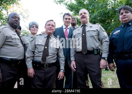 Austin Texas USA, September 11 2011: Texas Gov. Rick Perry (c) posiert bei einer Gedenkfeier am Twin Towers Monument auf dem Texas State Cemetery mit den Abgeordneten von Travis County nach seinem Gedenken an den 10. Jahrestag der Terroranschläge vom 11. September. Texanische Regierung. Rick Perry sagte der Menge, dass „die Bilder noch immer in unseren Köpfen bleiben und wir die an diesem Tag verlorenen Leben nie vergessen werden“. ©Bob Daemmrich Stockfoto