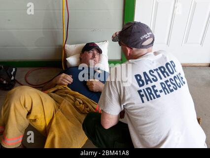 Bastrop Texas, USA, 7. September 2011: Feuerwehrleute machen an ihrer Feuerwache eine Pause, nachdem sie drei Tage lang an der Bekämpfung von Waldbränden in der Region gearbeitet haben. Die Brände zerstörten mehr als 1.400 Häuser und Gebäude und verbrannten mehr als 38.000 Hektar Land. ©Marjorie Kamys Cotera/Daemmrich Photography Stockfoto