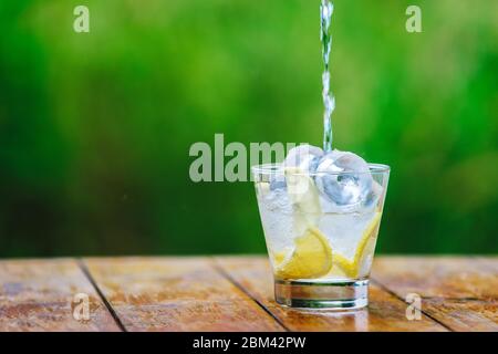 Wasser gießt in ein Glas mit Eis. Mineralwasser Stockfoto
