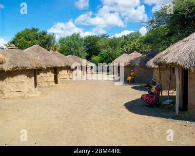 Arusha, Tansania - Mai 2011. Frau sitzt vor ihrem Haus. Stockfoto