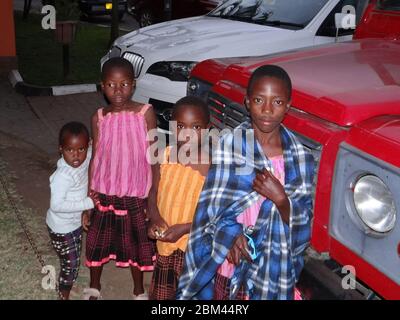 Arusha, Tansania - Sep, 2012. Kinder stehen in der Nähe des Autos und schauen auf die Kamera Stockfoto