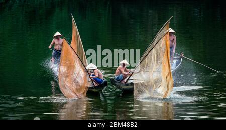 HUE - MÄR 07, 2018: Vietnamesische Fischer fangen Fische und kontrollieren das Netz auf zwei Booten vom friedlichen Song Nhu Y Fluss in Hue, Vietnam am 07 Stockfoto