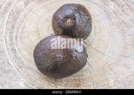 Hass Avocados zeichnen sich durch eine ovale Form, mittelgroß und kleinen Knochen aus. Die Schale ist sehr dicht, pimpliziert, wie es reift, wird es dunkel lila und Stockfoto