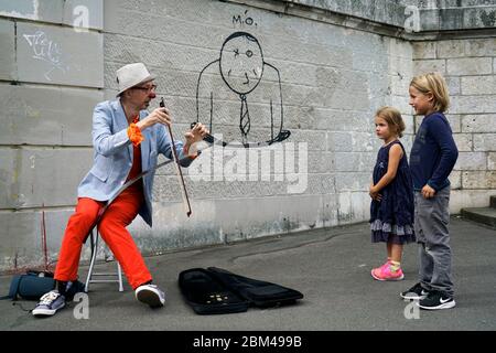 Ein Straßenkünstler Clown spielt Musik für Kinder in Montmartre.Paris.Frankreich Stockfoto