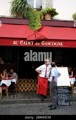 Kellner und Kunden.Außenplätze des Restaurants Brasserie des Au Cadet de Gascogne.Montmartre.Paris.Frankreich Stockfoto