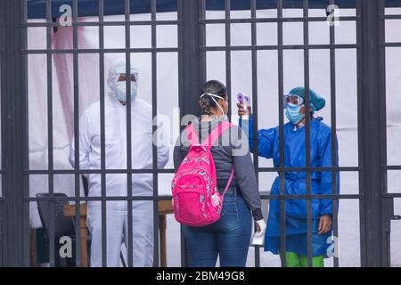 Das Gesundheitspersonal nimmt die Temperatur der Einwanderer, während sie aufgrund der Ausbreitung des pandemischen Corona-Virus auf ihre Rückkehr in ihr Land, Venezuela, warten Stockfoto