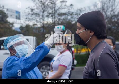 Das Gesundheitspersonal nimmt die Temperatur der Einwanderer, während sie aufgrund der Ausbreitung des pandemischen Corona-Virus auf ihre Rückkehr in ihr Land, Venezuela, warten Stockfoto