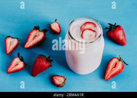 Erdbeer Milchshake im Glas blau vintage Hintergrund Stockfoto