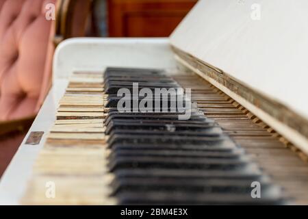 Vintage Retro-Zimmer-Einstellung mit Sofa, Accessoires, alte rostig weißen Klavier. Ideal für Postkarte. Altes Wohnzimmer, französischer Stil, viktorianische Details Stockfoto