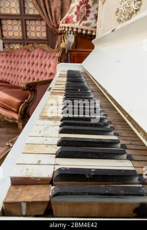 Vintage Retro-Zimmer-Einstellung mit Sofa, Accessoires, alte rostig weißen Klavier. Ideal für Postkarte. Altes Wohnzimmer, französischer Stil, viktorianische Details Stockfoto