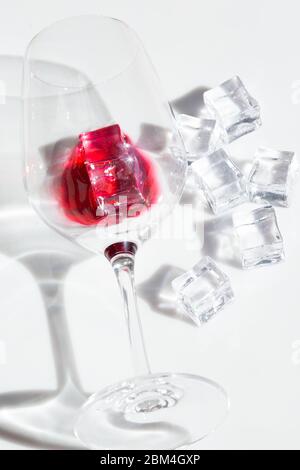 Ein Glas Rotwein und Eisstücke Stockfoto